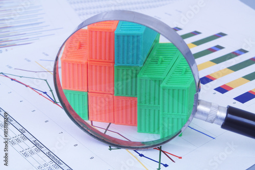 Many containers under magnifying glass on financial reports. Cargo and logistics concept.