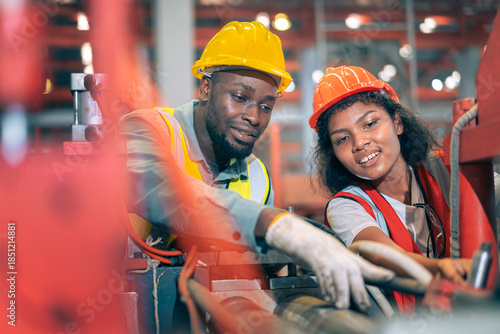 Two happy factory workers team African American man black woman engineer checking machine manufacturing plant Industrial safety helmet heavy industry teamwork production maintenance mechanic gear vest