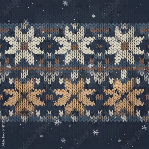 A close-up view of a knitted fabric with a repeating pattern of snowflakes and geometric shapes in shades of blue, brown, and cream.
