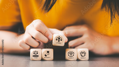 Code of conduct in business concept. Wooden blocks with code of conduct icons; code, integrity, honesty, respect, and ethics, the foundation of a strong corporate code of conduct. Corporate ethics. 
