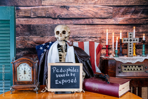 фотографія skeleton holding sign pedophiles need to be exposed