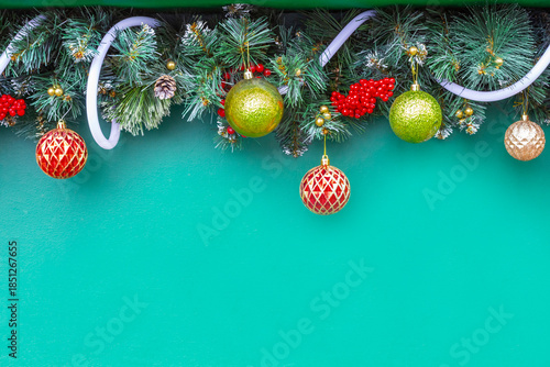 Fir garland with Christmas balls on a green background. Copy space.