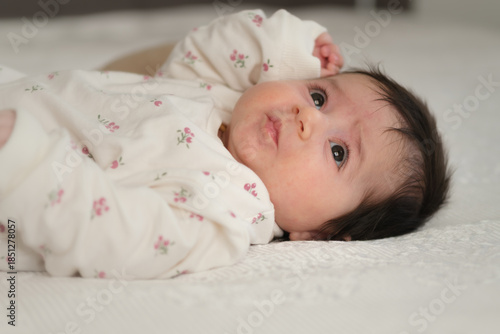 peaceful newborn baby resting on a soft bed at home.