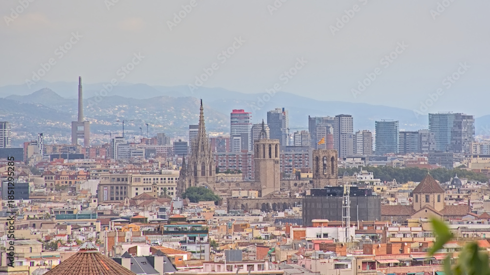 Obraz premium Aerial view on the city of Barcelona, with apartment buildings and skyscrapers on a cloudy day.