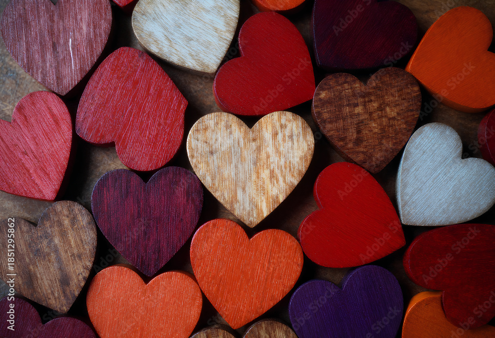 Obraz premium A top-down view of tightly arranged wooden hearts showcases rich wood grain and natural tones for artisanal product marketing.