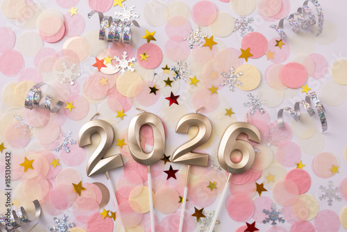Gold candles shaped like the numbers 2026 on festive background of confetti and stars. Template for a New Year's card or calendar. Selective focus