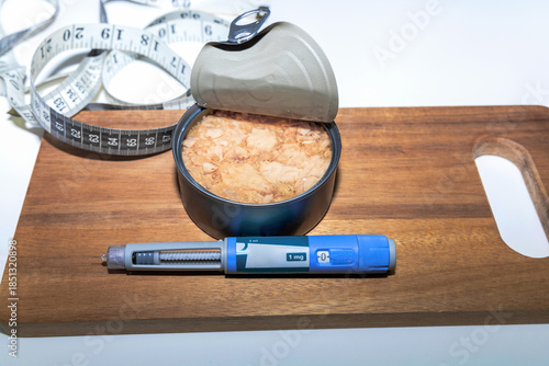 Weight loss concept featuring tuna fish and ozempic pen.