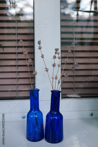 blue vase with flowers on the window sill