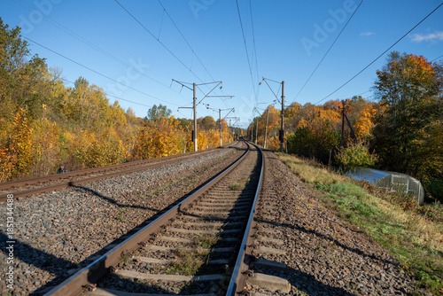 Double Railway Tracks Curving Through Colorful Autumn Forest in Paneriai, Lithuania