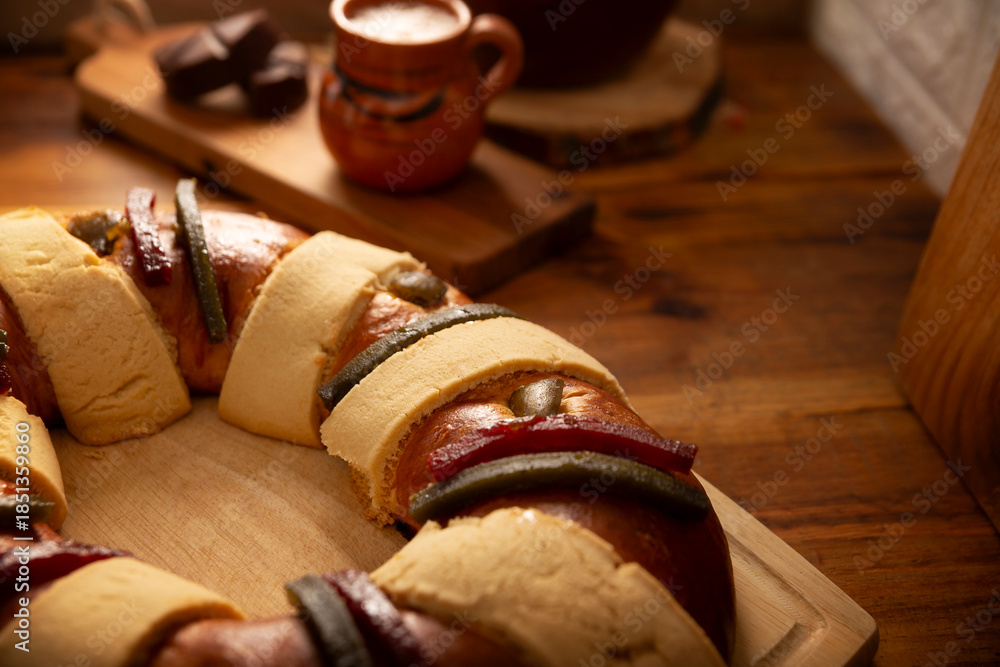 Fototapeta premium Rosca de Reyes, also called Three Kings Bread, Roscon, Epiphany Cake, traditionally served with hot chocolate in a clay Jarrito. Mexican tradition on January 5th.