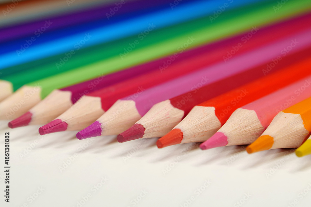 Obraz premium New wooden colored pencils of rainbow colors, perfectly sharpened, lie on table