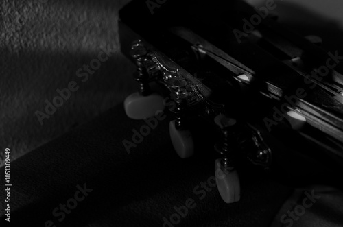Close-up photo of an acoustic guitar with shadows. Guitar strings, neck, frets and body