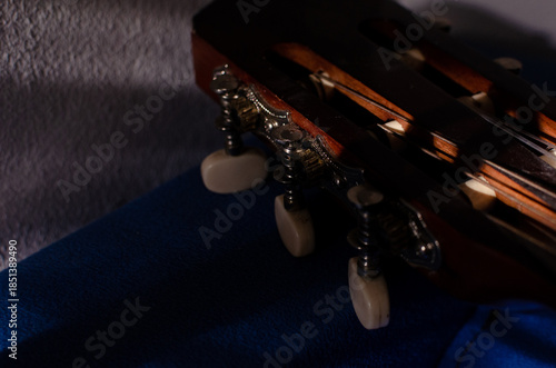 Close-up photo of an acoustic guitar with shadows. Guitar strings, neck, frets and body