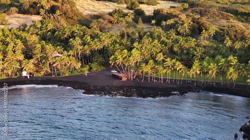 Aerial view of Hawaii Punaluʻu Beach black sand landscape capturing lush coastlines on the Big Island in Hawaii County, Hawaii during morning sunrise - 4K Drone