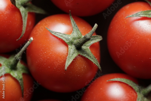 Cherry tomatoes with water drops close up studio shot over