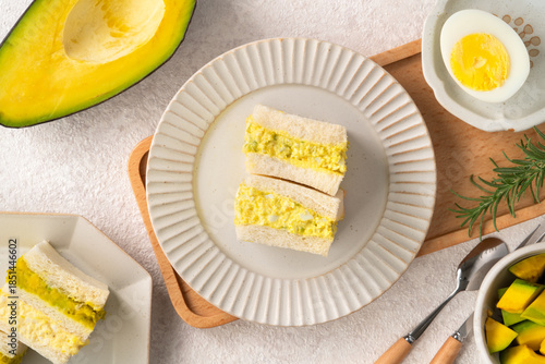 Healthy avocado and egg salad sandwich on white plate for breakfast