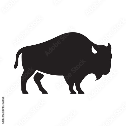 A striking black silhouette of a powerful bison standing in profile