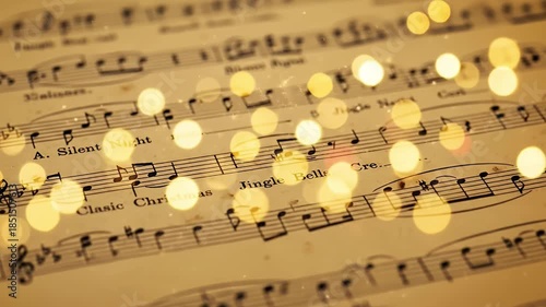 A captivating close-up captures the intricate details of vintage sheet music, displaying classic musical notation and lyrics on aged, sepia-toned paper. Shimmering golden bokeh lights dance softly acr