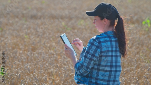 Photography A young woman is actively using her smartphone in a vibrant field full of sunshi