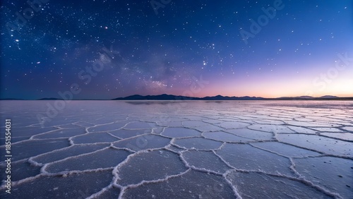 A breathtaking nature landscape view of the sun rising over the desert and sea horizon with white clouds reflecting light across the water and salt travel destination
