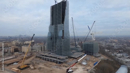 A massive construction timelapse of a glass skyscraper being built from ground to completion with cranes and steel beams against a city skyline, concept of corporate ambition and architectural achieve