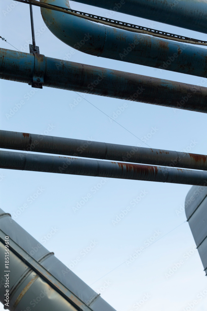 Naklejka premium Structural pipes against cloudy sky, Repeated metal elements shape architectural art, Industrial metal constructions with intersecting pipes form intricate architectural visual compositions