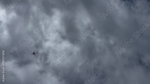 Commercial Airplane Silhouette Flying Through Dense Grey Storm Clouds
