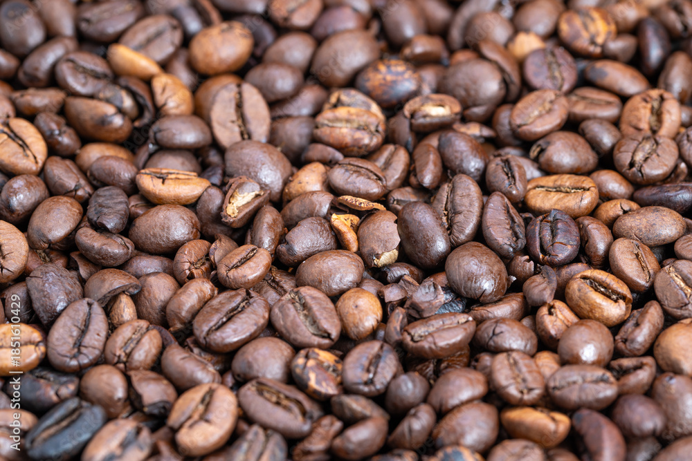 Naklejka premium Ideal espresso shot display, Highquality glossy coffee beans for barista commercial use, Closeup shot of glossy dark roasted coffee beans perfect for advertising and branding