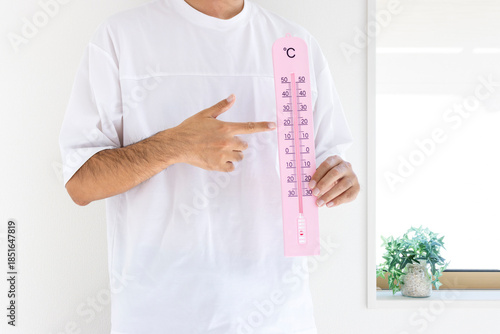 大きな温度計を持つ男性（日本人、顔無し、30代）_夏