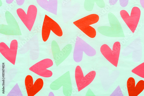 Cute colorful heart pattern background texture. Red, pink, and green hearts on paper. Romantic love concept for Valentine's Day greeting card, wrapping design or sweet wedding wallpaper.
