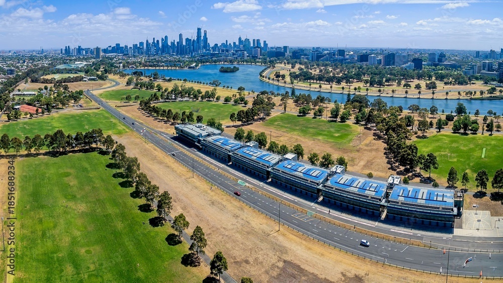 Fototapeta premium An aerial view of the Albert Park Grand Prix Circuit infrastructure, featuring the pit lane buildings and track. The view extends over Albert Park Lake toward