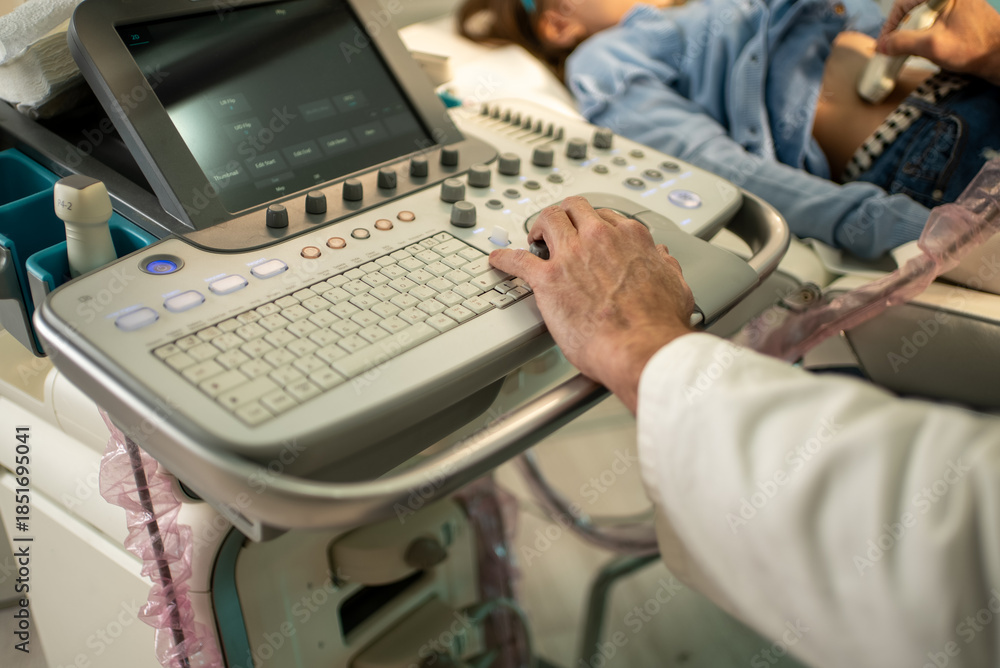 Obraz premium Doctor operating ultrasound machine on a child patient for medical examination