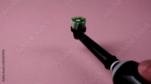 Electric toothbrush on pink background. Modern brush for professional oral hygiene.