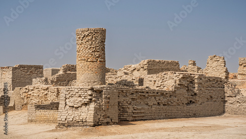 Cityscape view of ancient house walls and long brick well in archaeological ruins of UNESCO World Heritage Mohenjo-Daro, Larkana, Sindh, Pakistan