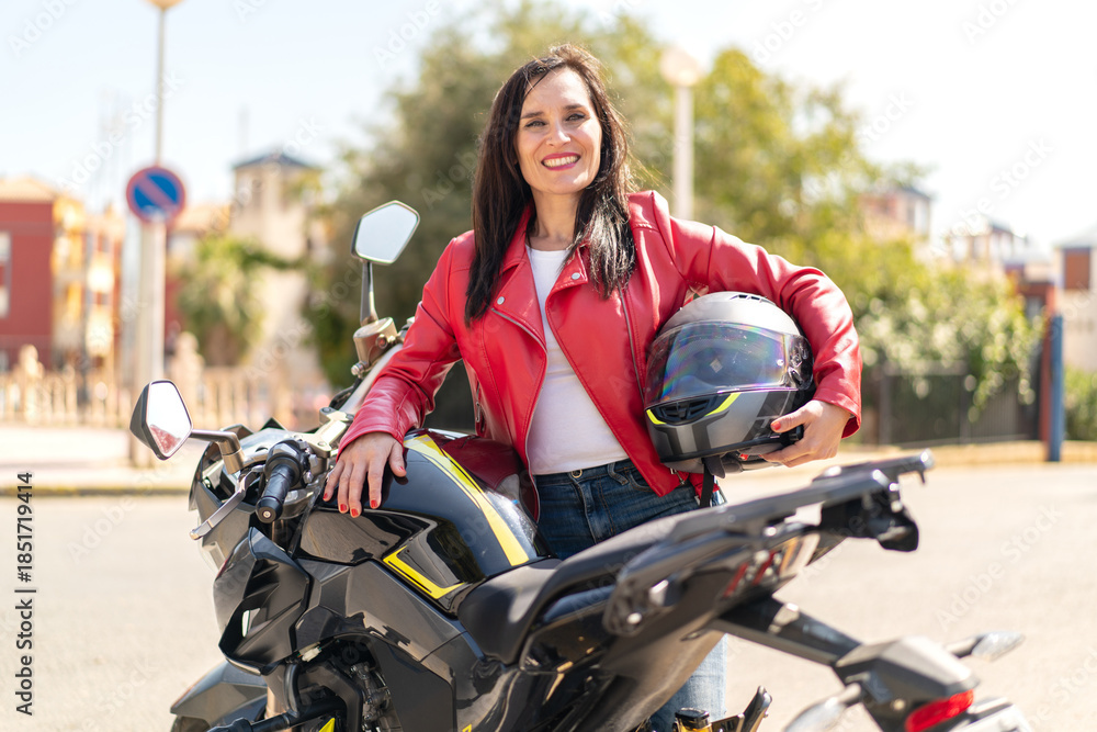 Obraz premium Middle aged woman with a motorcycle at outdoors