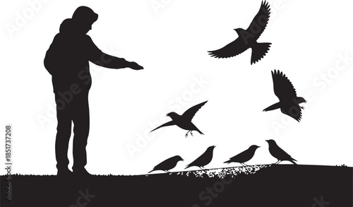Silhouette of person feeding birds in winter landscape