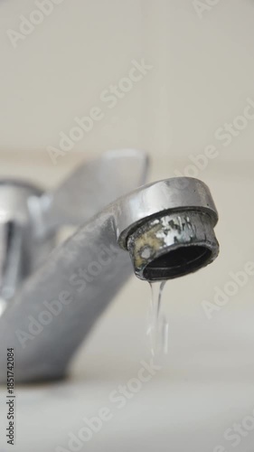 Leaking water tap with dripping water. Plumbing problem and home maintenance. Water conservation and sustainability awareness.