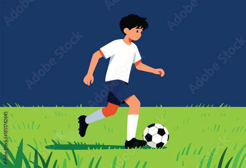 Young boy plays soccer on a grassy field under a dark blue sky