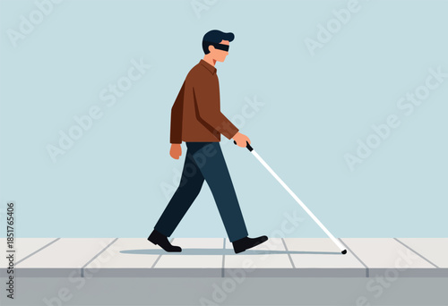 Visually impaired person walks with cane on sidewalk