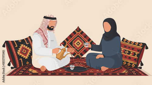 A man in traditional Saudi attire pours coffee for a woman in a hijab, seated on a rug with cushions.