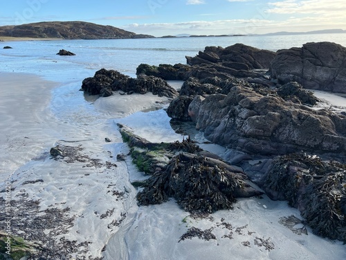 Beautiful wild beach Isle of Mull Scotland Uisken the beautiful rocky and sandy shore sunrise with water pools reflect sun light  vast ocean on horizon with wildlife  and blue sky in Winter no people