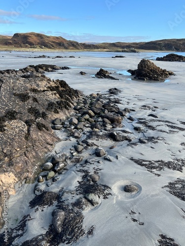 Beautiful wild beach Isle of Mull Scotland Uisken the beautiful rocky and sandy shore sunrise with water pools reflect sun light  vast ocean on horizon with wildlife  and blue sky in Winter no people