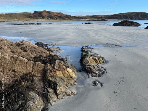 Beautiful wild beach Isle of Mull Scotland Uisken the beautiful rocky and sandy shore sunrise with water pools reflect sun light  vast ocean on horizon with wildlife  and blue sky in Winter no people