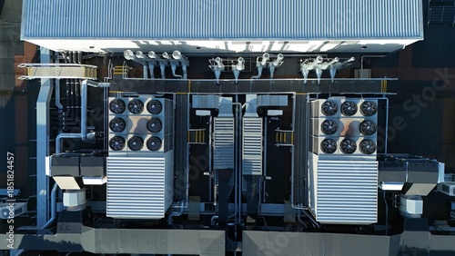 Aerial drone top down rotating view of cooling and ventilation systems on a data storage center warehouse building showing modern infrastructure.