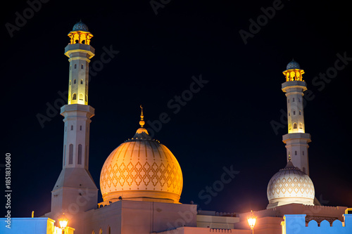 Sur, Oman - November 22,2025: Close-up Night View of the Distinctive Illuminated Dome and Minaret of Bahwan Mosque in Sur, Oman