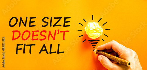One size does not fit all symbol. Concept words One size does not fit all on beautiful paper. Beautiful orange background. Businessman's hand. Business one size does not fit all concept. Copy space.