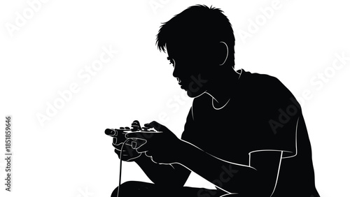 Silhouette of a focused boy intensely playing a video game with a wired controller