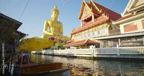 Big golden buddha statue river side with wooden boat sightseeing travel in Bangkok Thailand