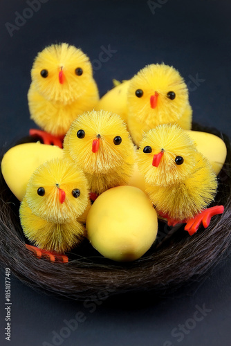 Yellow fluffy baby chicks for Easter cake decorations ready for easter against a dark background.