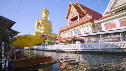 Big golden buddha statue river side with wooden boat sightseeing travel in Bangkok Thailand